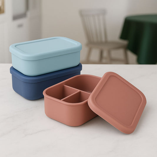 Stacked set of ZipNow silicone everyday lunch boxes in blue and rust colors — modern reusable containers on a marble kitchen surface
