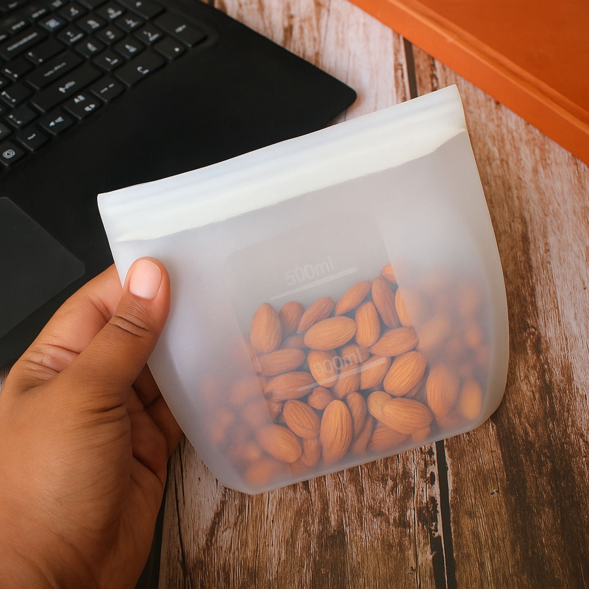 ZipNow Silicone Smart Bag storing almonds next to a laptop on a work desk
